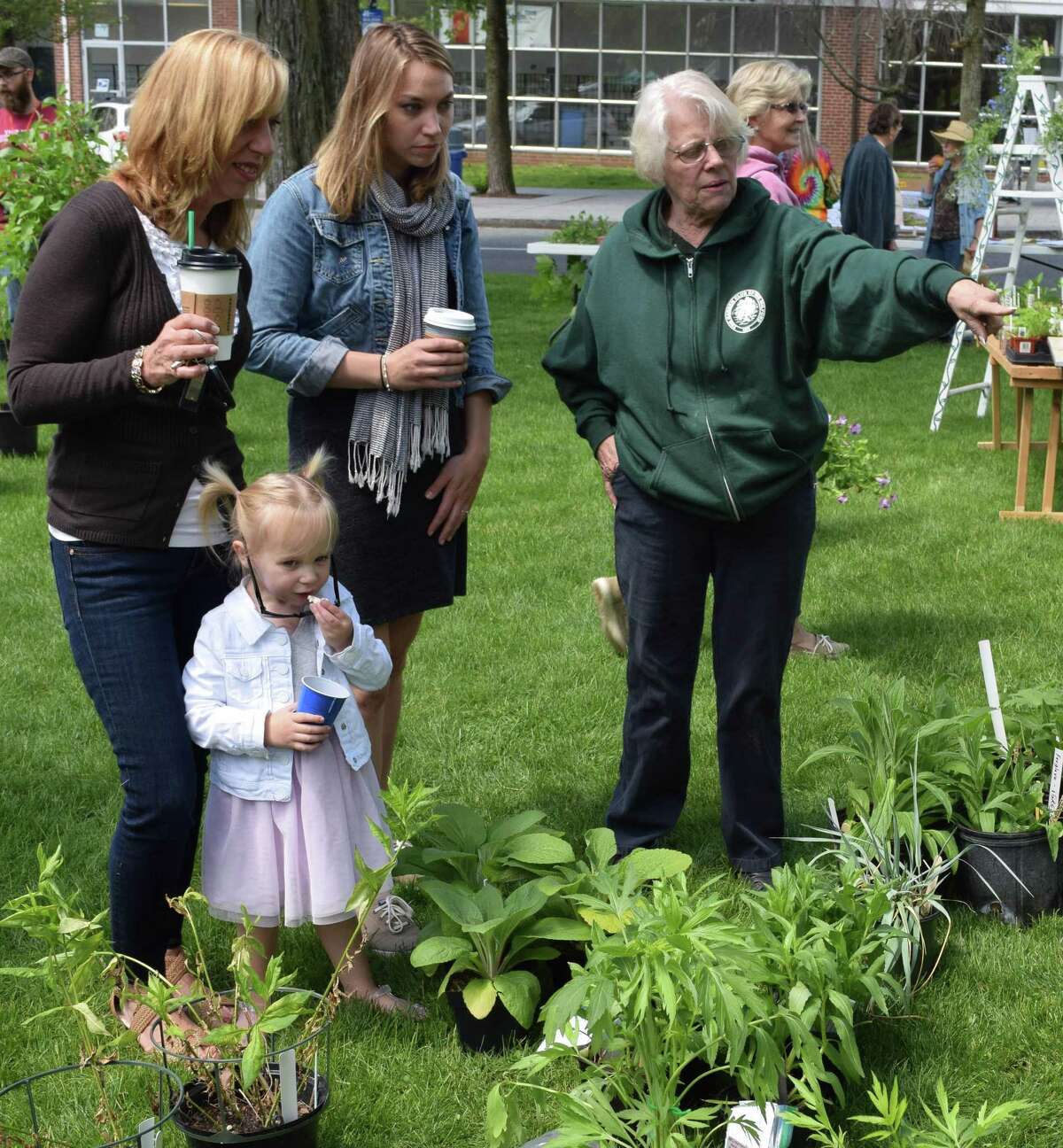 Spectrum/Cynthia Chilson of Brookfield, left, and Lauren Chilson of Warren talk with Ann Stone of the Garden Club of New Milford as Layla Pfeifer, 2, of New Milford, niece of the Chilsons, passes the time munching on popcorn.
