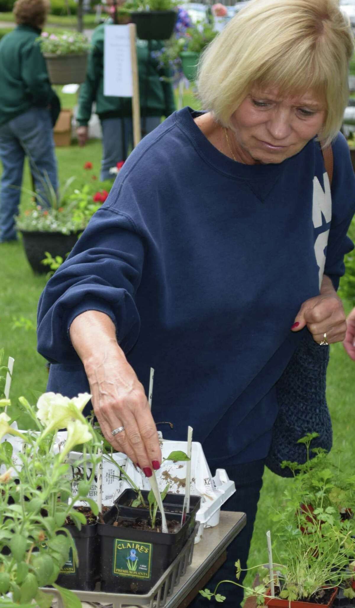 Kathy Matusiak of New Milford admires the variety of items, including sweet bell peppers, available at the Garden Club sale.