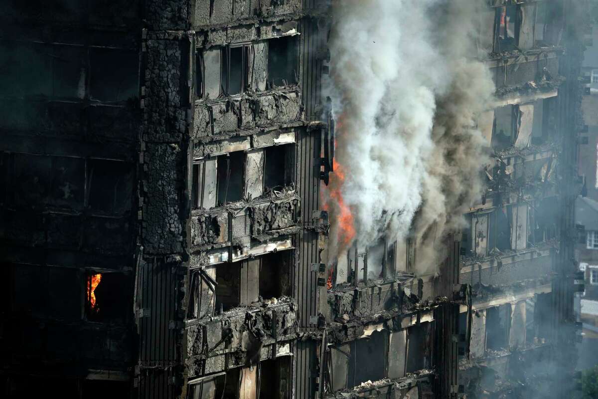 Parts of the building still burn hours after a deadly blaze at a high rise apartment block in London, Wednesday, June 14, 2017. Fire swept through a high-rise apartment building in west London early Wednesday, killing an unknown number of people with around 50 people being taken to hospital. (AP Photo/Alastair Grant)