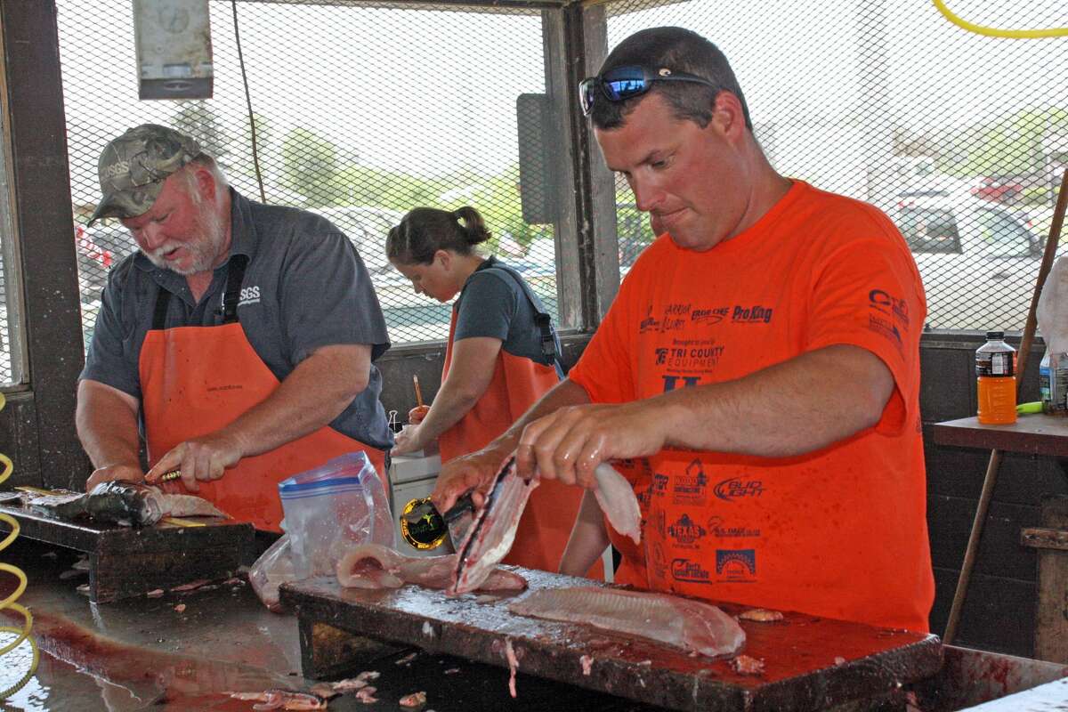   Volunteers clean some of the hundreds of fish caught for veterans to take home at a recent veteran’s fishing outing. 