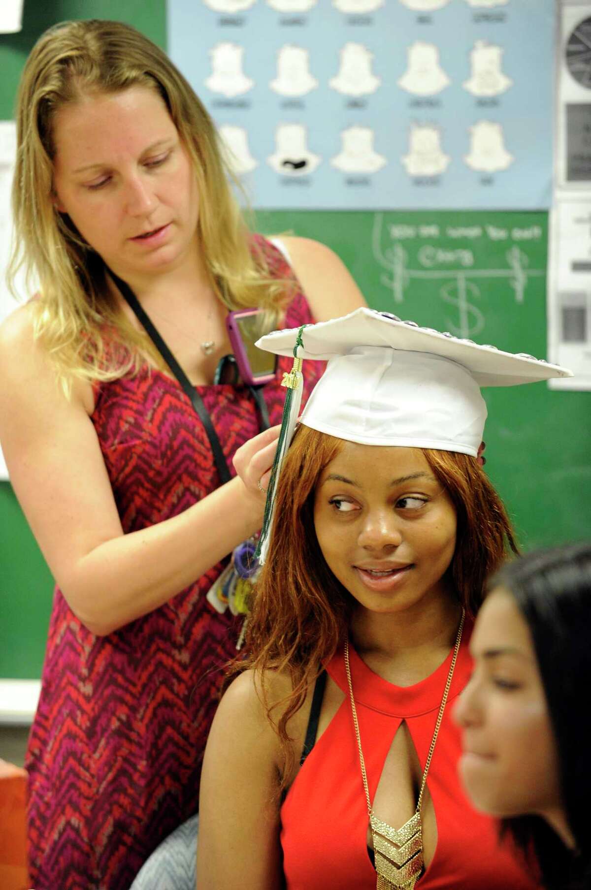 Rebecca Dickinson, who teaches English help Alexis Brown with her cap prior Stamford Academy graduation at Trailblazers Academy for in Stamford, Conn., on Wednesday, June 14, 2017.