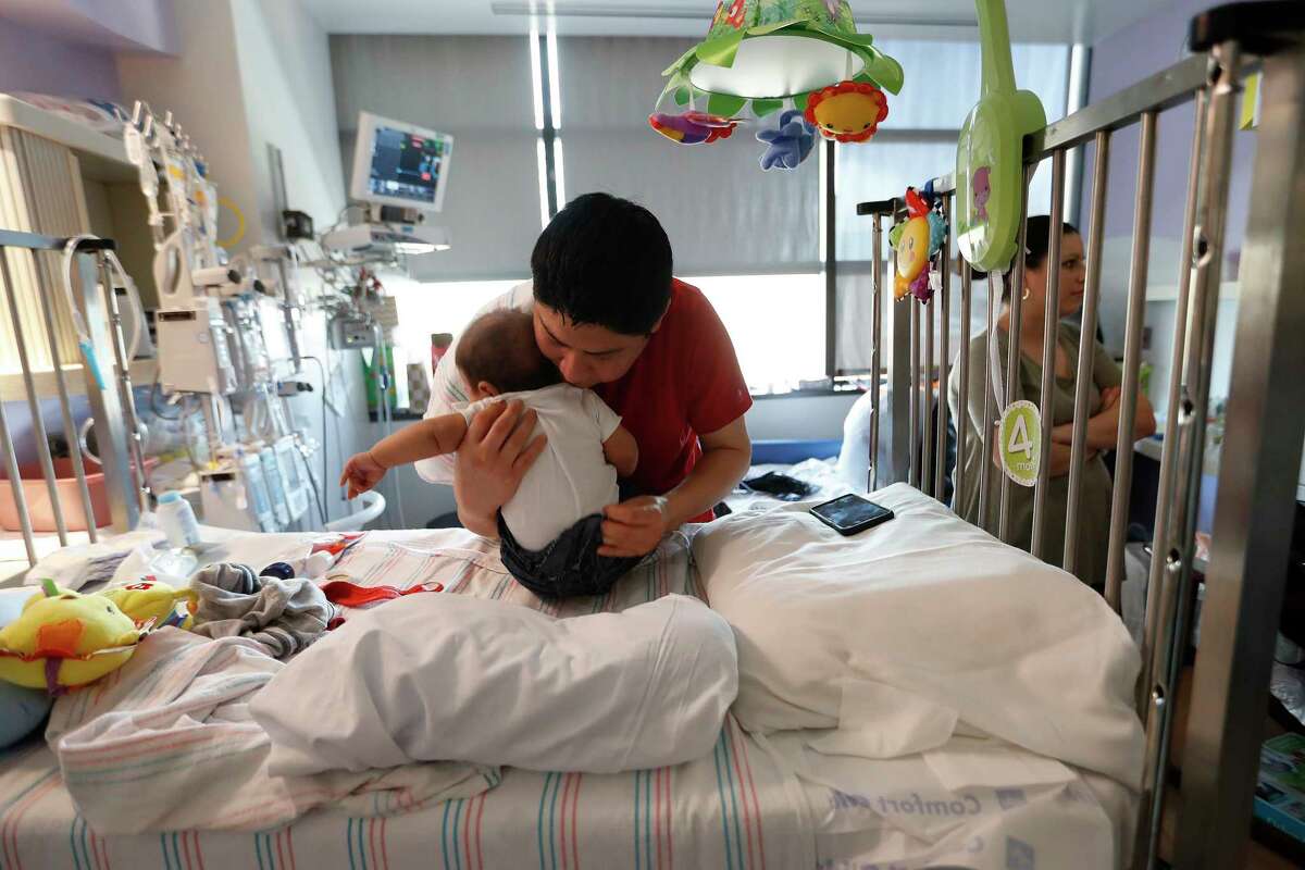Emil Romero dresses his son, Sebastian in a pair of coveralls as they prepared to be discharged from Texas Children's Hospital, Wednesday, June, 14, 2017. Sebastian was born without an immune system.