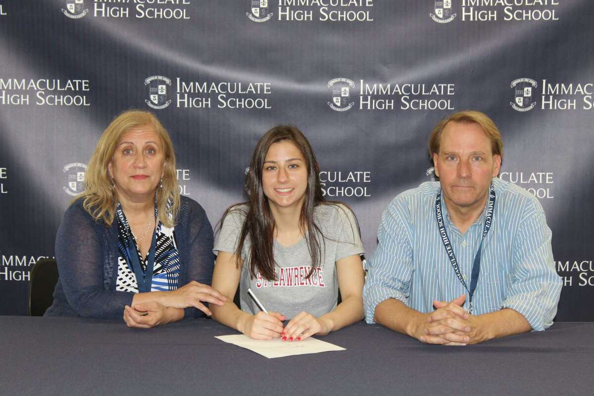 During a recent signing-day ceremony, Immaculate High School senior Rachel Meurer signs her letter of intent to swim for St. Lawrence University,