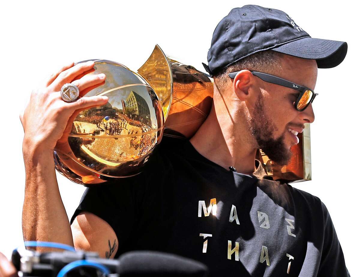 Golden State Warriors' Stephen Curry holds the Larry O'Brien trophy during championship parade on Broadway in Oakland, Calif., on Thursday, June 15, 2017.