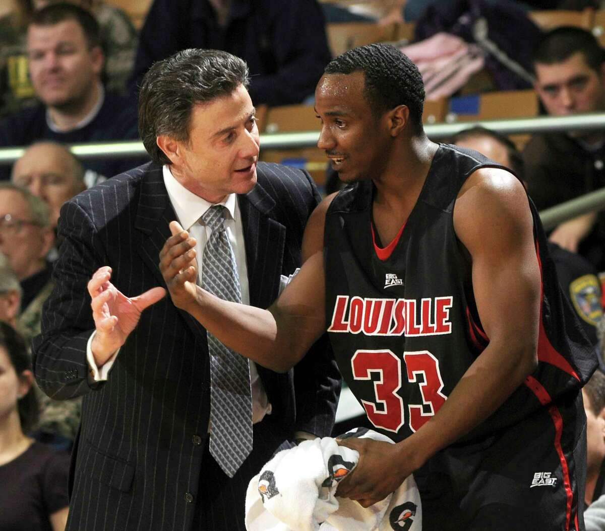 FILE - In this Feb. 12, 2009, file photo Louisville coach Rick Pitino, left, talks with guard Andre McGee during the first half of an NCAA college men's basketball game against Notre Dame in South Bend, Ind. The NCAA suspended Pitino, Thursday, June 15, 2017, for five ACC games following sex scandal investigation. A former men's basketball staffer is alleged to have hired strippers to entertain players and recruits. In addition, the governing body also placed the basketball program on four years' probation, vacated wins in which ineligible players participated and handed down a 10-year show-cause order for former basketball operations director Andre McGee. (AP Photo/Joe Raymond, File)