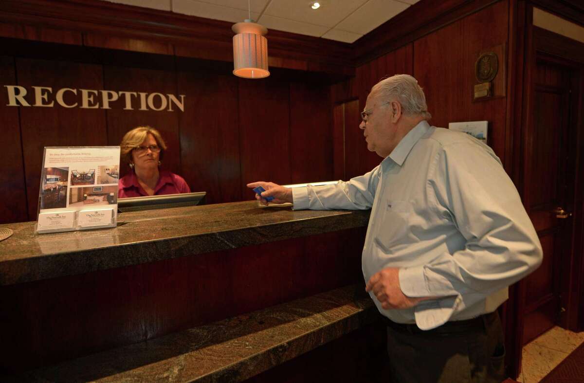 Norwalk Inn & Conference Center owner Chris Handrinos chats with receptionist Betty Morrell on May 2017. Handrinos says Airbnb has had little impact on his hotel, with new state data supporting that contention in the 11 months since Connecticut has forced Airbnb to collect and remit lodging taxes.