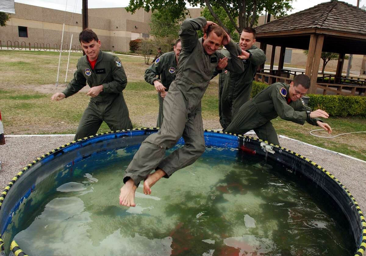 METRO - UNDERGRADUATE PILOT TRAINING PROGRAM FRIDAY, APRIL 5, 2002 AT LAUGHLIN AIR FORCE BASE. Instructor pilot Rob Hamill is thrown into the Pogo Pool by some of his student pilots after his first student's solo flight. Tradition holds that when a student makes their first pogo (solo flight) or an IP's first student pogos, they are thrown into the pool. BAHRAM MARK SOBHANI/STAFF
