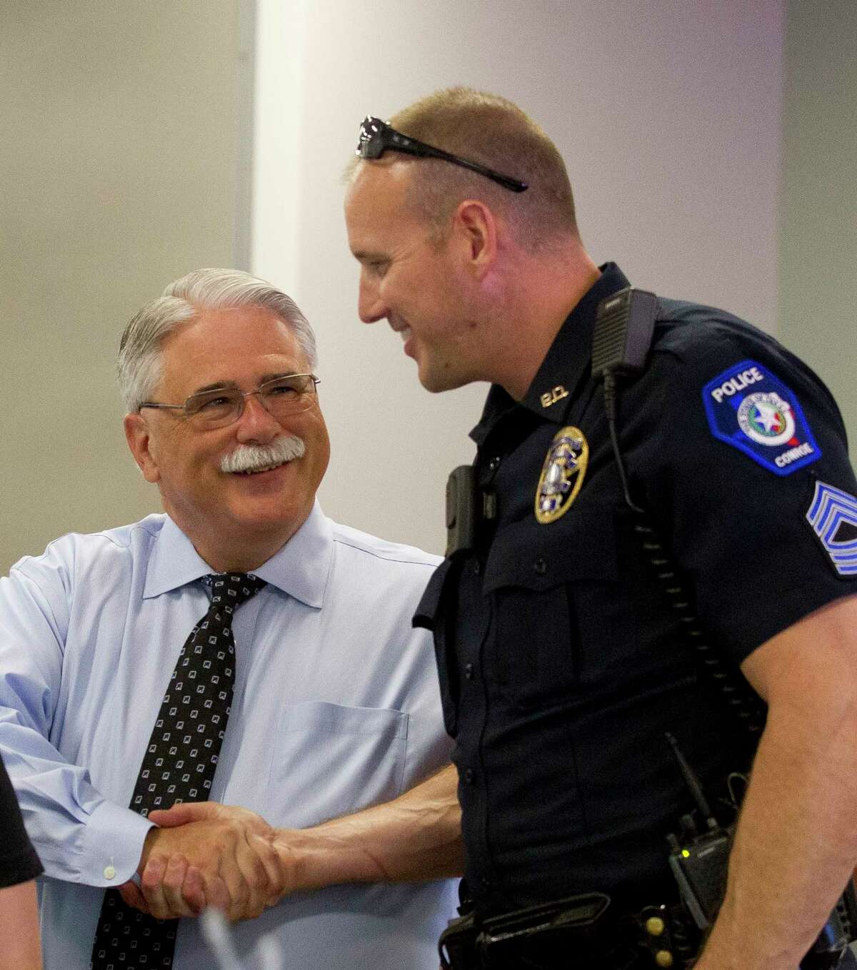 Conroe Police Lt. Bob Berry, left, shakes hands with Sgt. Brent Stowe during Berry's retirement party at the Conroe Police Department and Municipal Courts building Thursday, June 15, 2017, in Conroe.