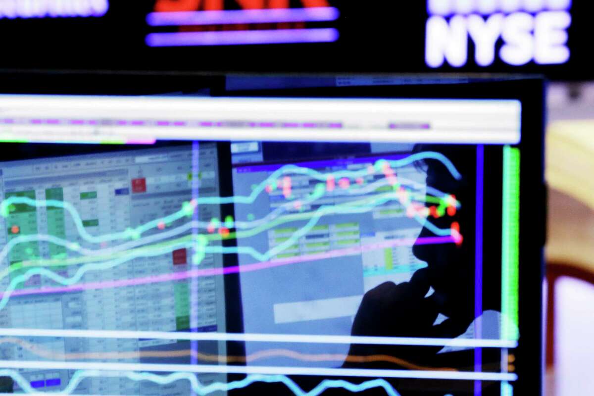 FILE - In this Monday, Jan. 11, 2016, file photo, specialist Anthony Rinaldi is silhouetted on a screen at his post on the floor of the New York Stock Exchange. Stocks are at peak levels. Bonds are making money despite a raft of predictions to the contrary at the start of 2017. Even stock markets overseas, notoriously poor investments for much of the last decade, are perking higher. If it feels precarious to have so many investments doing so well, even when the economy itself is still growing only modestly, markets are giving few indications of worry. But contrarians are feeling more reasons to pause. (AP Photo/Richard Drew, File)