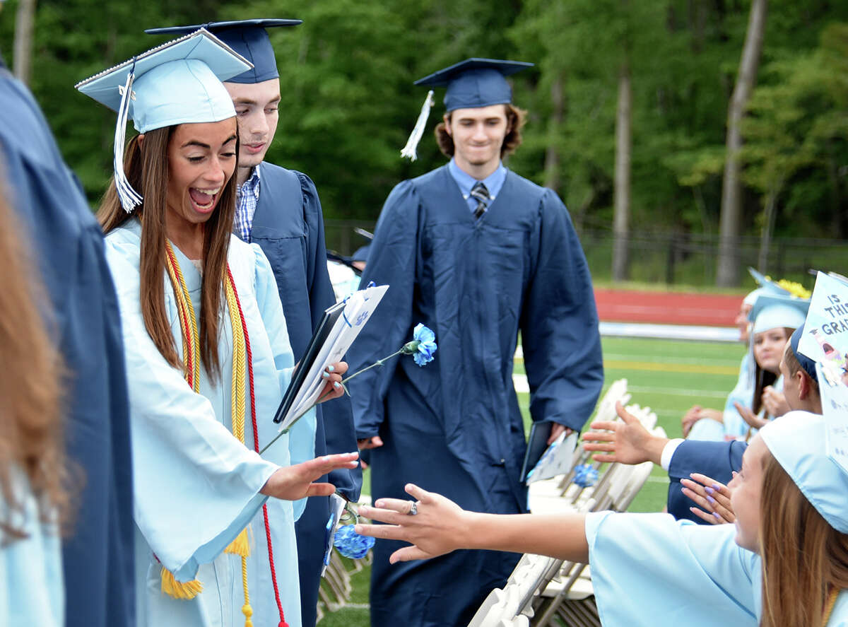 Marisa Bruno high fives a fellow graduate after receiving her diploma at the Oxford High School commencement ceremony in Oxford, Conn. on Thursday, June 15, 2017.