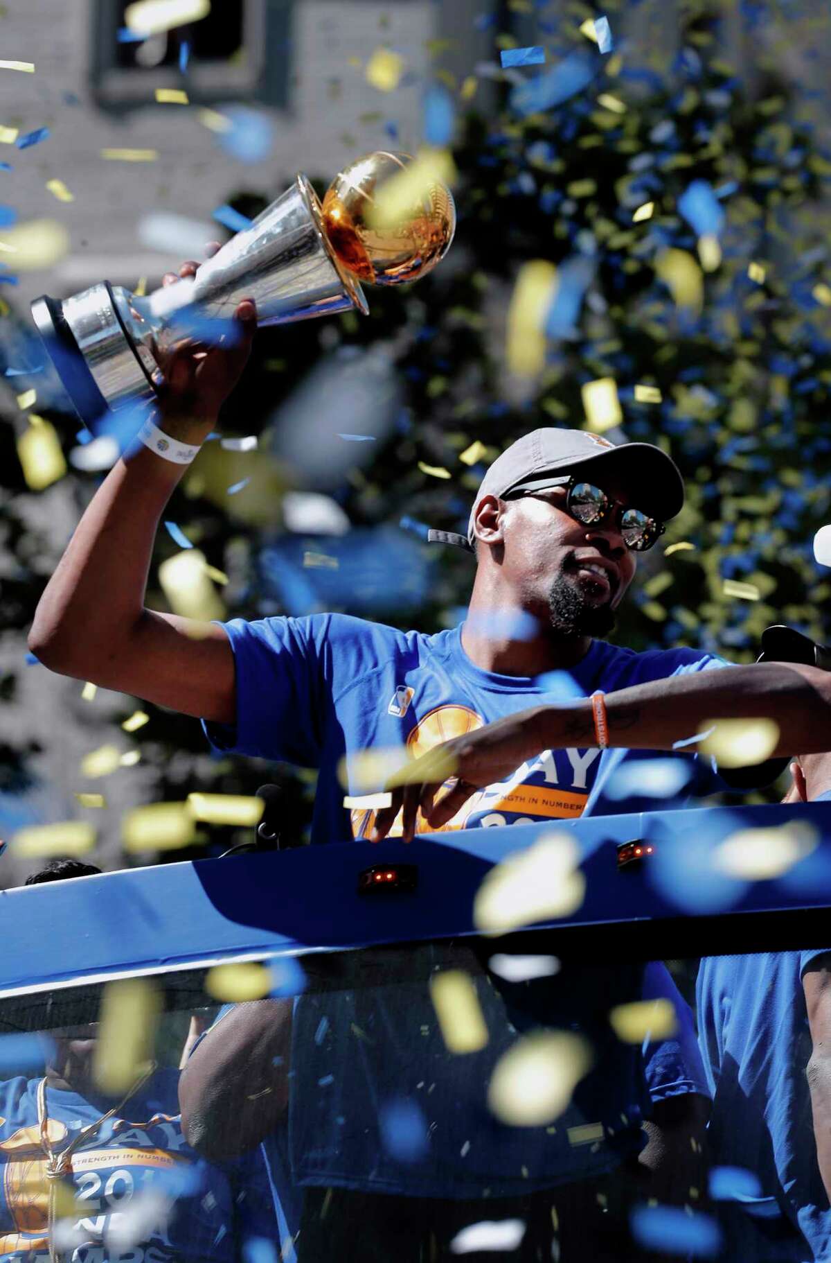 Kevin Durant holds the MVP trophy during the Golden State Warriors' NBA championship victory parade through downtown Oakland on Thursday.