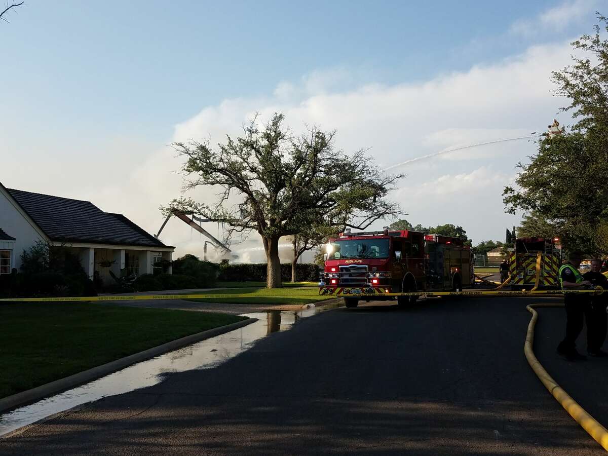 Midland firefighters continue to put water on hot spots Thursday evening after a fire destroyed a home under construction on Racquet Club Drive.