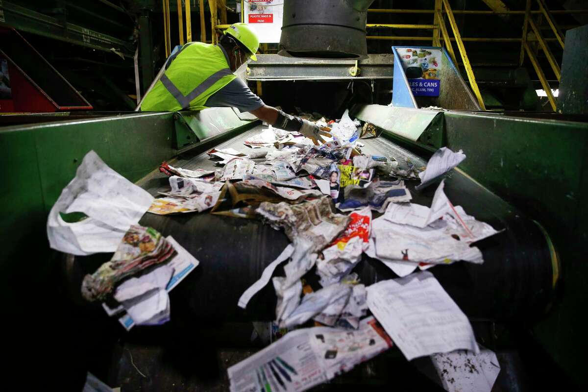 A Waste Management employee sorts through paper at the Gasmer Recycling Center Friday, June 2, 2017 in Houston. ( Michael Ciaglo / Houston Chronicle )