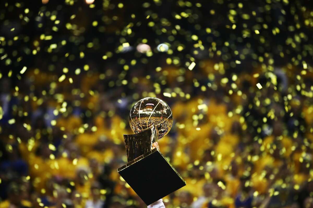 OAKLAND, CA - JUNE 12: The Larry O'Brien Championship Trophy is held up by the Golden State Warriors after the defeated the Cleveland Cavaliers 129-120 in Game 5 to win the 2017 NBA Finals at ORACLE Arena on June 12, 2017 in Oakland, California. NOTE TO USER: User expressly acknowledges and agrees that, by downloading and or using this photograph, User is consenting to the terms and conditions of the Getty Images License Agreement. (Photo by Ezra Shaw/Getty Images)