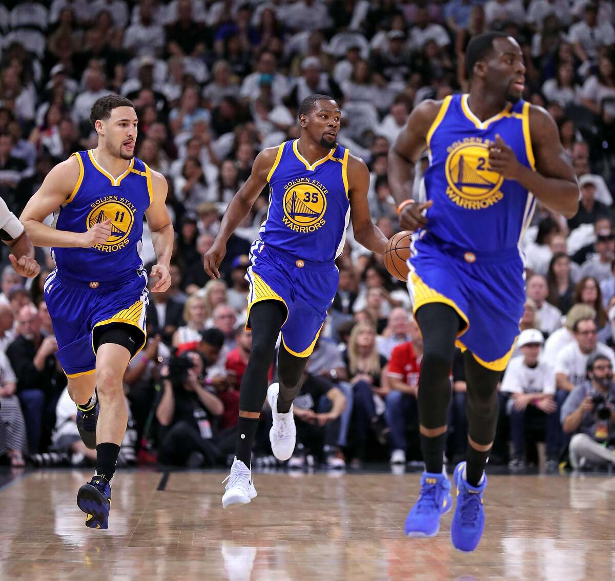 Golden State Warriors' Kevin Durant brings the ball up court flanked by Klay Thompson and Draymond Green in 1st quarter against San Antonio Spurs'during Game 3 of NBA Western Conference Finals at AT&T Center in San Antonio, Texas, on Saturday, May 20, 2017.