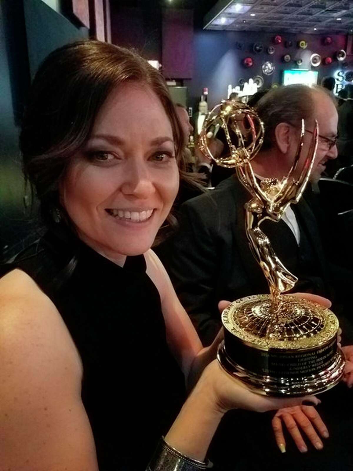 Kim Wells holds her Emmy award.