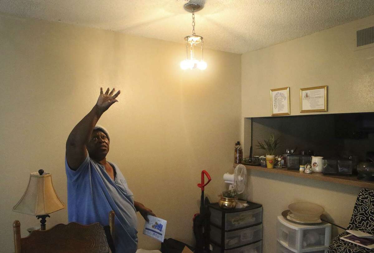 Hellene Hunt gestures toward the ceiling that she said would leak whenever there was a rainstorm. It took the management of her apartment complex, Avistar at Chase Hill, more than a year to fix the leaks, she said.