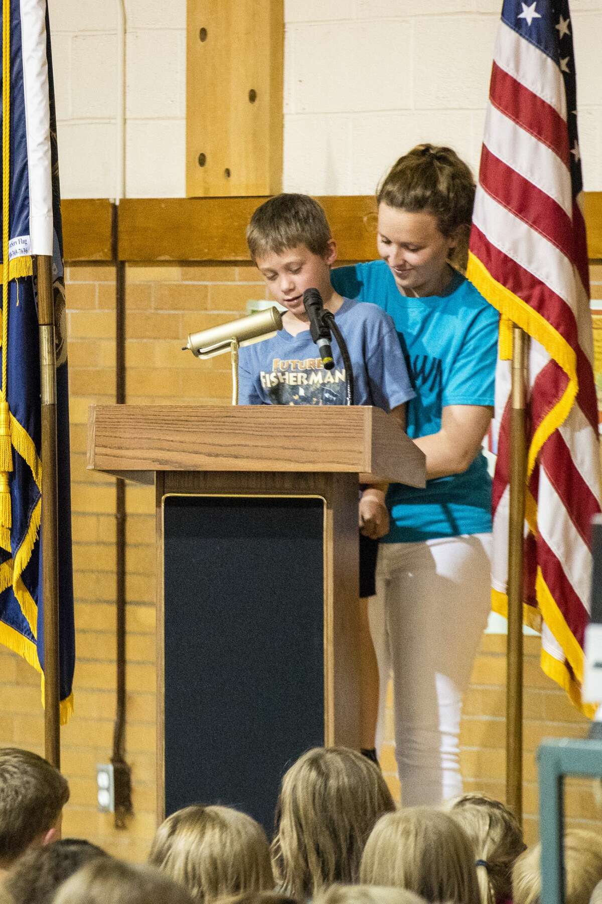 DANIELLE McGREW TENBUSCH | for the Daily News Danny Wontorcik reads a tribute he wrote about Eastlawn Elementary as Lindy Coon gives him a boost during a farewell party at Eastlawn Elementary School in Midland. Starting with the 2017-18 school year, Eastlawn and Carpenter Street elementary schools will combine under the roof of the new Central Park Elementary School, which will have a STEM focus.