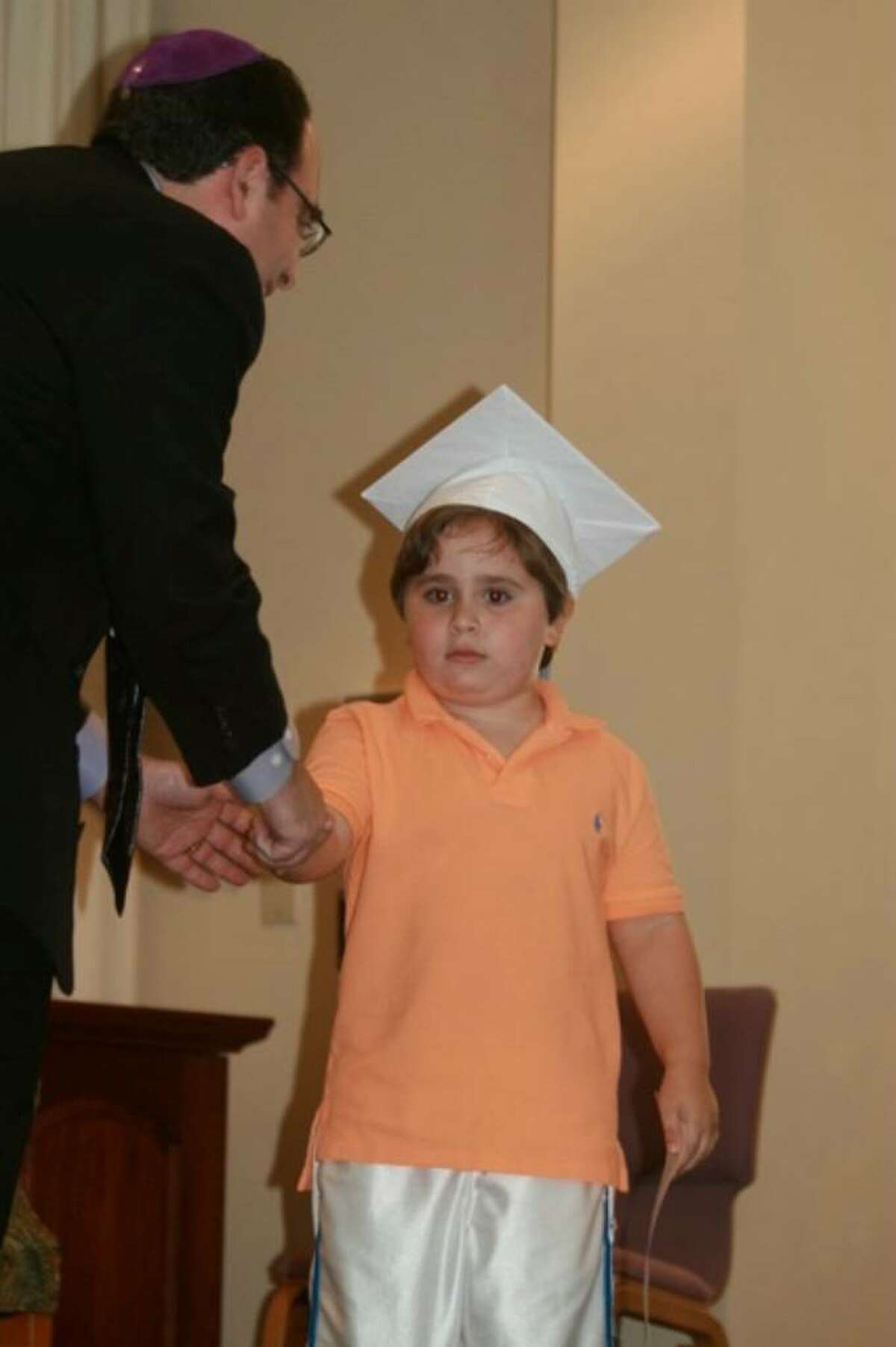 Rabbi Jeremy Wiederhorn of The Conservative Synagogue in Westport congratulates Ari Perkins of Westport as he graduates from the 4's program at the Synagogue's preschool.