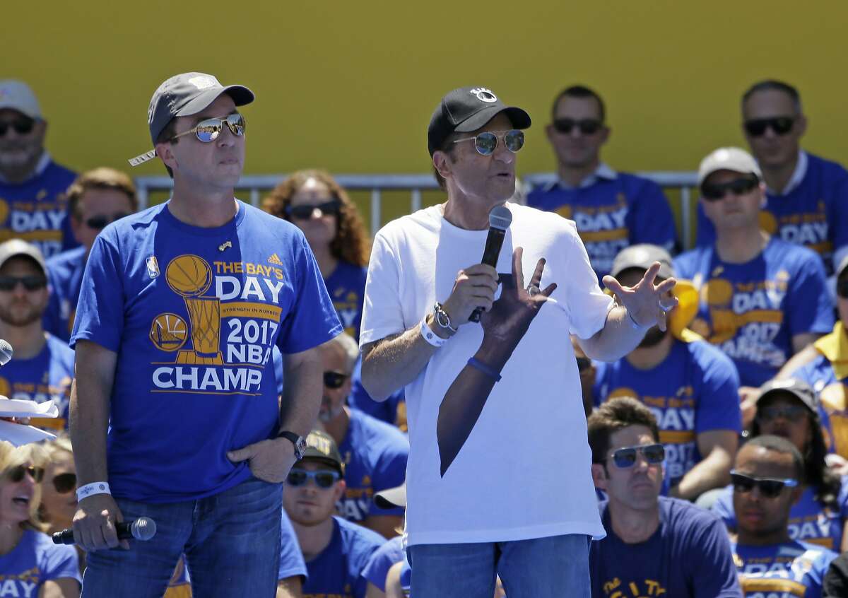 Team owners Joe Lacob, left, and Peter Guber, right, speak during the Golden State Warriors NBA championship rally Thursday, June 15, 2017, in Oakland, Calif. Oakland is celebrating its second championship in the past three years. (AP Photo/Eric Risberg)