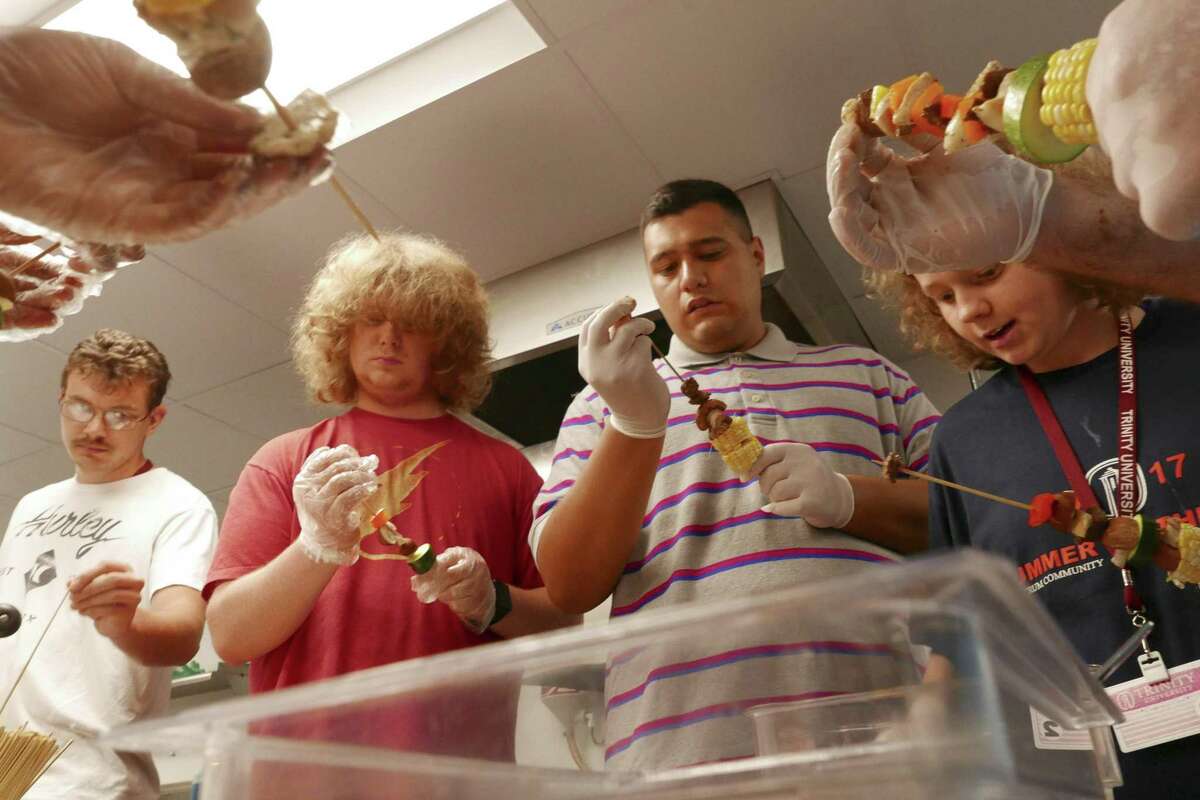 From left, Austin Hardeman, Sam Fesko, Gilbert Vasquez and Bailey Rapson assemble kabobs as they prepare a meal at the San Antonio Clubhouse on Wednesday, June 14, 2017. Trinity University and the Spectrum Community nonprofit are having a week of classes to teach autistic people how to be independent and prepare them for college.
