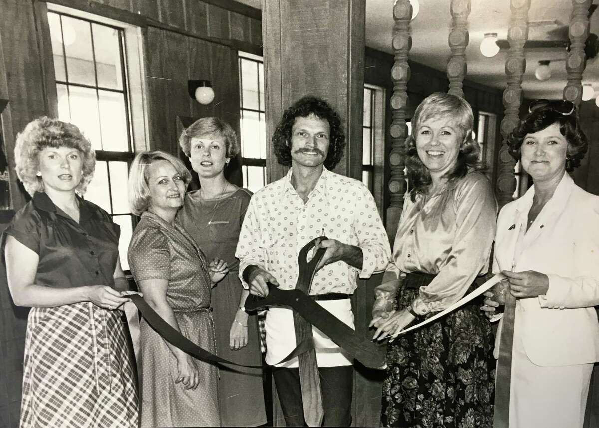 A Chamber ribbon cutting at the Old West Steakhouse on Texas 105. Chamber Embassy Club members assisting owner Michael Edwards, center, are Patty Calfee, Charline Utley, Sue Scripture, Lana Hughes and Sally Copley. Photo taken in the 1970s/80s era.