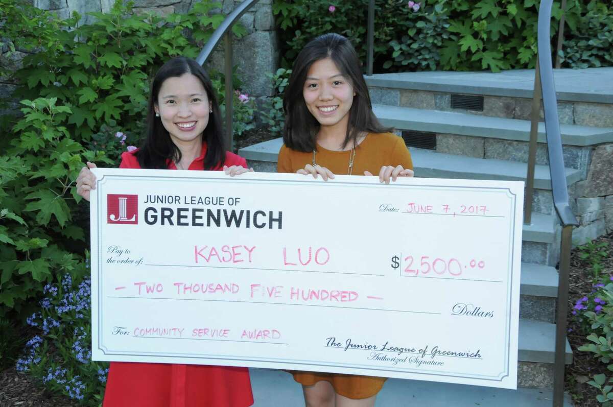 Cos Cob resident Kasey Luo receives a check from Joselynn Chua and the Junior League of Greenwich for her community service work.