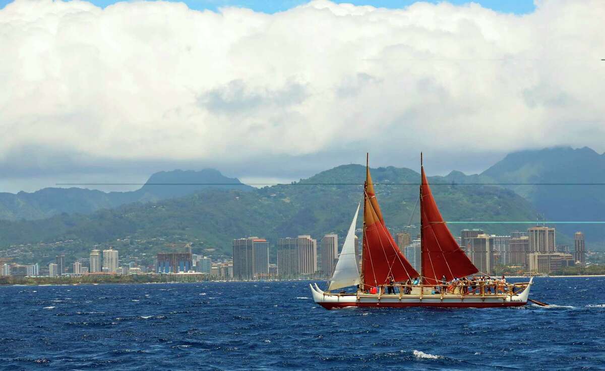 FILE - In this April 29, 2014 file photo, the Hokulea sailing canoe is seen off Honolulu. The Polynesian voyaging canoe is returning to Hawaii after a three-year journey around the world guided only by nature with navigators using no modern navigation to guide Hokulea across 40,000 nautical miles to 19 countries. Thousands are expected to welcome the double-hulled canoe to Oahu, Hawaii, on Saturday, June 17, 2017. (AP Photo/Sam Eifling, File)