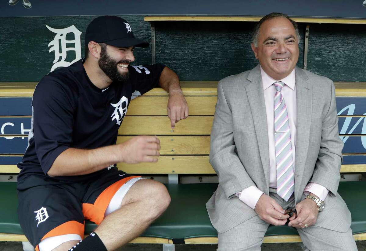 In this Friday, May 19, 2017 photo, Detroit Tigers' Alex Avila, left, shares a laugh with his father, general manager Al Avila during an interview in the dugout in Detroit. Al strives to strike a balance between business and personal with his son, Alex, who plays catcher for the team. The Avilas are one of many father-son duos in sports around the world spending time together on a daily basis. (AP Photo/Carlos Osorio)