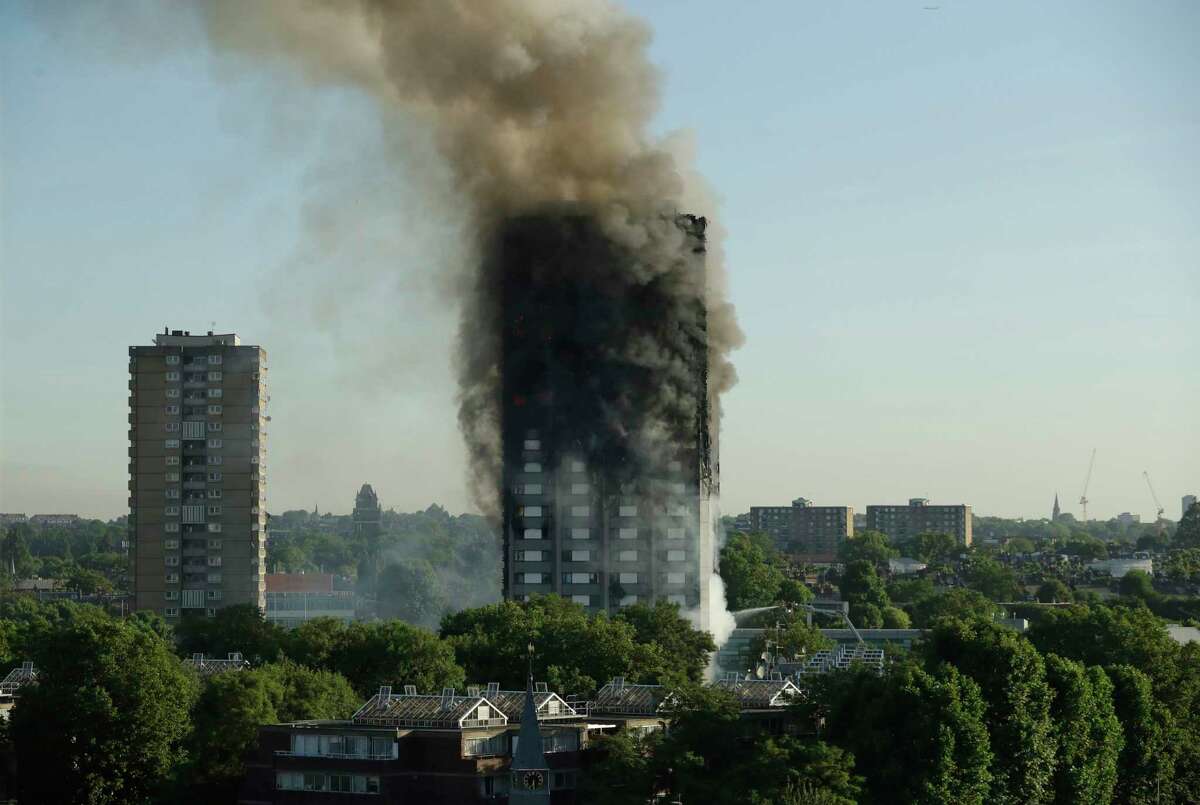 FILE- In this June 14, 2017 file photo, smoke rises from a 24-story high-rise apartment building on fire in London. Fire safety experts say despite that outcome, "stay put" is still the best advice if fire breaks out in a different part of a high rise building. The recommend sheltering in place as long as the building has proper fire suppression protections, like a sprinkler system, fireproof doors and flame-resistant construction materials.( AP Photo/Matt Dunham, File) ORG XMIT: NYR402