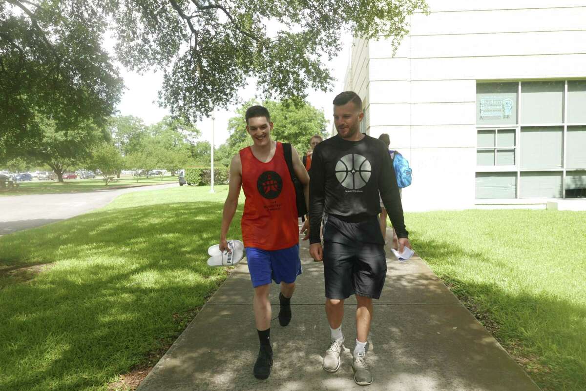 Andi Vrapcani, who hails from Kosovo, left, walks with coach Dustin Karrer on the campus of Our Lady of the Lake University during the Basketball Embassy summer basketball camp on Tuesday, June 13, 2017.