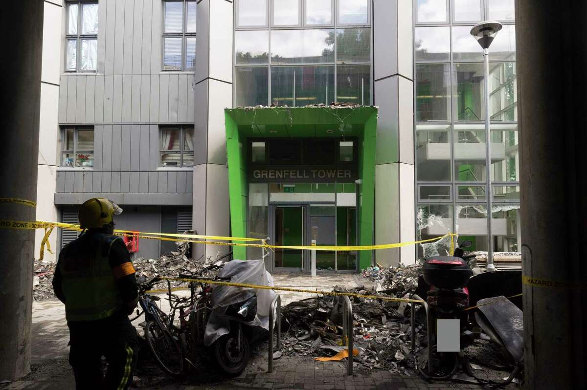 In this photo released by the Metropolitan Police on Sunday, June 18, 2017, a firefighter stands outside of the Grenfell Tower after fire engulfed the 24-storey building, in London. ??Experts believe the exterior cladding, which contained insulation, helped spread the flames quickly up the outside of the public housing tower early Wednesday morning. Some said they had never seen a building fire advance so quickly. The 24-story tower that once housed up to 600 people in 120 apartments is now a charred ruin. (Metropolitan Police via AP)