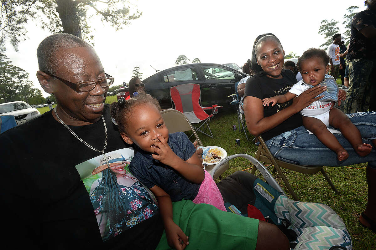 Kenneth Jones gets a cuddle from his daughter Kadtera Jones, 3, as his wife Cassandra Broussard, holding their baby Kenneth, Jr., looks on as they and nearly 80 members of their extended family gather for their annual reunion and celebration at the the City of Beaumont's Juneteenth celebration in Tyrrell Park Saturday. The holiday commemorates the June 19, 1865, announcement of the abolition of slavery in Texas as well as the broader emancipation of African-American slaves throughout the Confederate South. In addition to enjoying the event and time together, the family, which was largely representing the Broussard, Walker, Lawrence, and Harmon branches of relatives, was also celebrating a family member's birthday, a high school graduate, and Father's Day. Photo taken Saturday, June 17, 2017 Kim Brent/The Enterprise