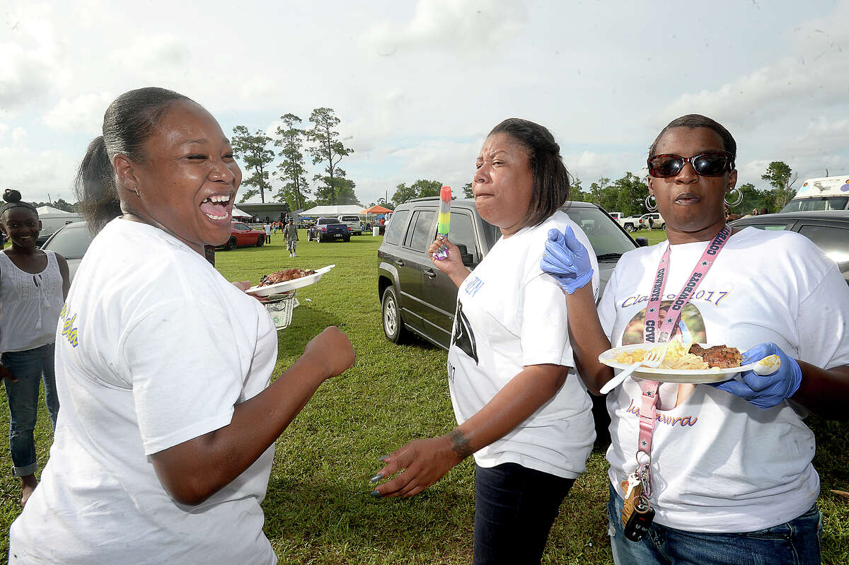 From left, cousins Eureka Anderson, Jessica Moore, and Alonda Williams dance and joke with one another as they and nearly 80 members of their extended family gather for their annual reunion and celebration at the City of Beaumont's Juneteenth celebration in Tyrrell Park Saturday. The holiday commemorates the June 19, 1865, announcement of the abolition of slavery in Texas as well as the broader emancipation of African-American slaves throughout the Confederate South. In addition to enjoying the event and time together, the family, which was largely representing the Broussard, Walker, Lawrence, and Harmon branches of relatives, was also celebrating a family member's birthday, a high school graduate, and Father's Day. Photo taken Saturday, June 17, 2017 Kim Brent/The Enterprise