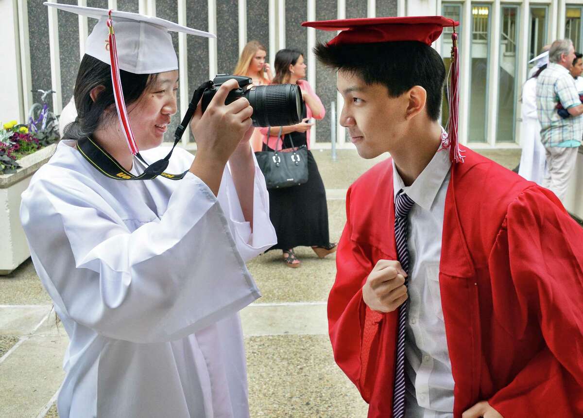Grads Qingxi Liu, left, and Zesen Lai share a light moment before graduation ceremonies for Guilderland High School at SEFCU Arena Saturday June 27, 2015 in Albany, NY. (John Carl D'Annibale / Times Union)