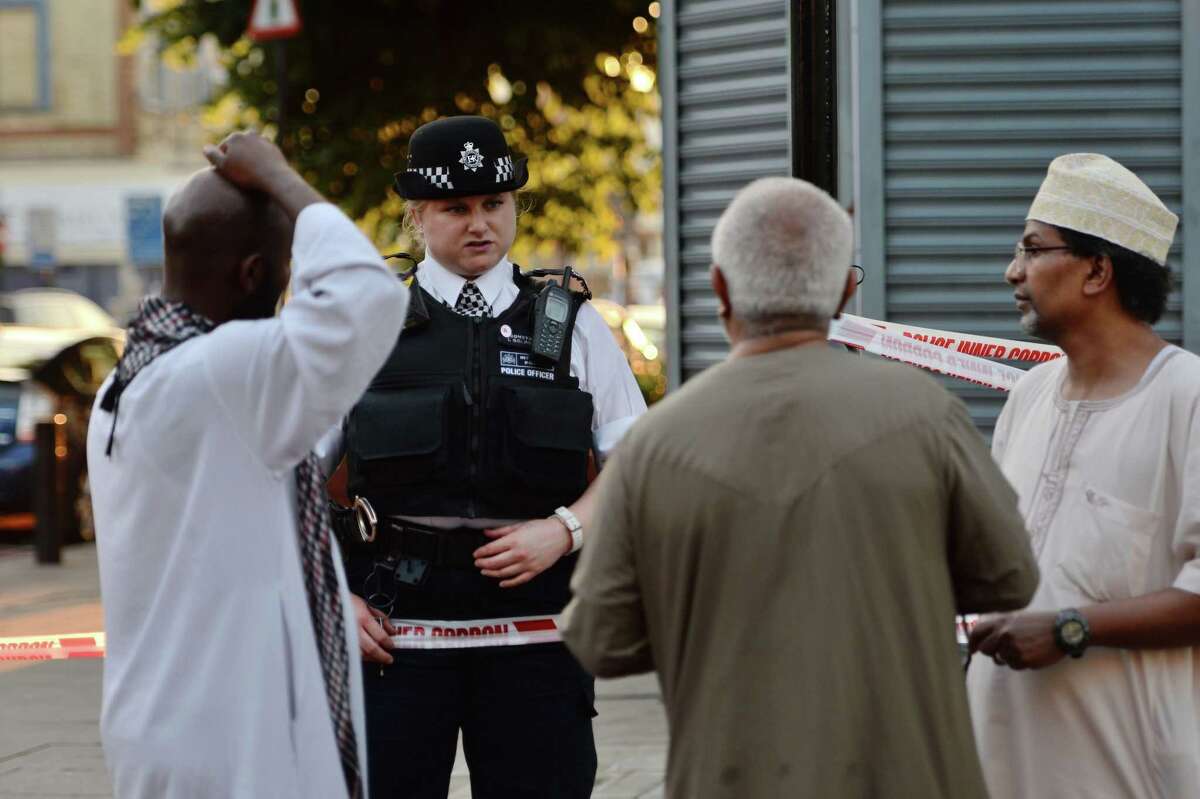 A police officer talks to local people at Finsbury Park in north London, where a vehicle struck pedestrians in north London Monday, June 19, 2017. A vehicle struck pedestrians near a mosque in north London early Monday morning. (Victoria Jones/PA via AP)