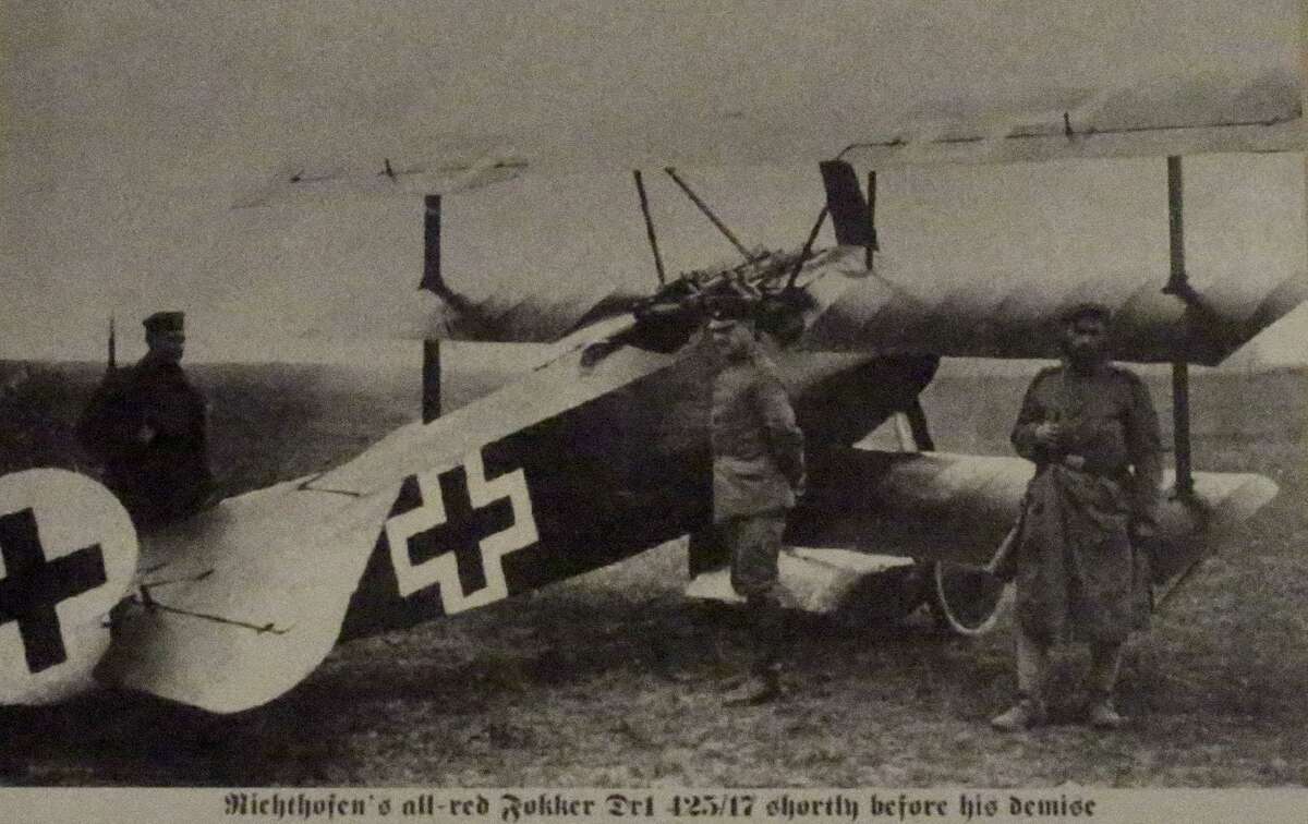 A picture of Manfred von Richtofen (center) next to a Fokker triplane he flew is on display at the Institute of Texan Cultures in its World War I exhibit. Richtofen was famously known as the "Red Baron."