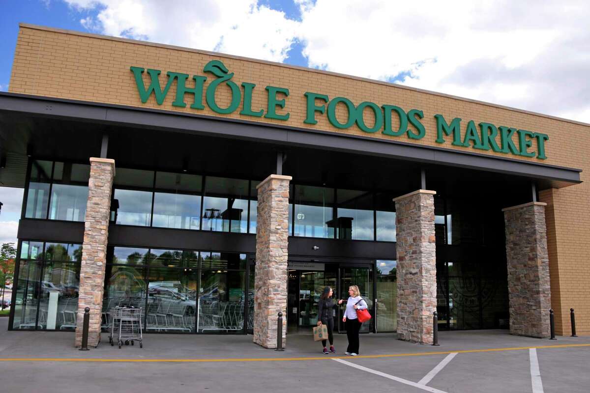 In this May 3, 2017, photo, people stand outside a Whole Foods Market in Upper Saint Clair, Pa. Amazon'?’s planned $13.7 billion acquisition of Whole Foods signals a massive bet that people will opt more for the convenience of online orders and delivery or in-store pickup, putting even more pressure on the already highly competitive industry. 