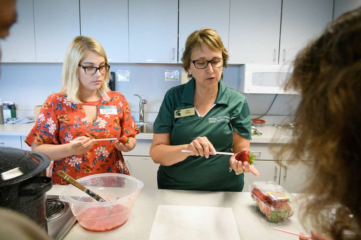 Co-op Cora Hickey and Lisa Treiber from the MSU Extension office in Midland County teaching at a jam and jelly making class Thursday evening.