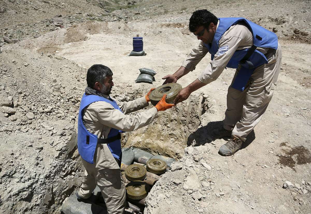 In this Wednesday, May 24, 2017, photo, de-miners from The HALO Trust de-mining organization collect anti-tank mines to be destroyed on the outskirts of Kabul, Afghanistan. Afghans who scratch out a living by removing some of the country�s countless land mines have long had to contend with rugged terrain, accidental explosions and the threat of kidnapping _ but these days they face the added risk of being laid off. (AP Photo/Rahmat Gul)