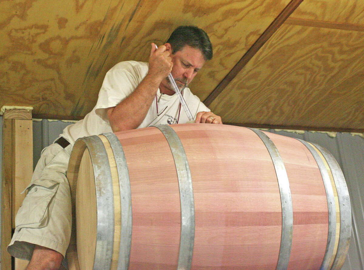 Jerry Bernhardt, owner of Bernhardt Winery in Plantersville, takes a sample out of a barrel of wine for testing. Bernhardt Winery will be harvesting their Blanc du Bois grapes on Saturday and the winery is looking for volunteers to help harvest the grapes.