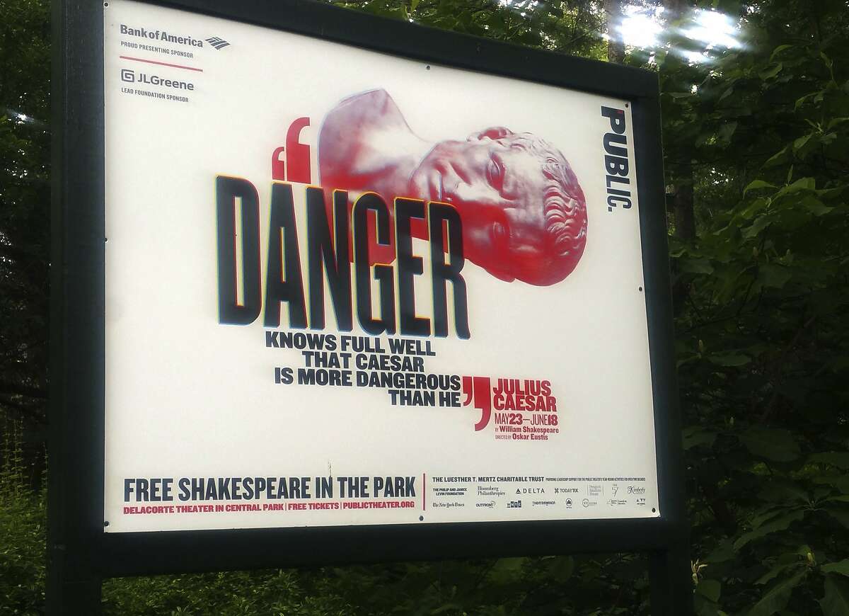 In this June 7, 2017 photo, "Danger knows full well that Caesar is more dangerous than he," reads a sign promoting The Public Theater's production of Julius Caesar in New York's Central Park. Police say they arrested a woman during the Friday, June 16, performance, and charged her with criminal trespass and disorderly conduct for getting up on stage and disrupting the play. (AP Photo/Verena Dobnik)