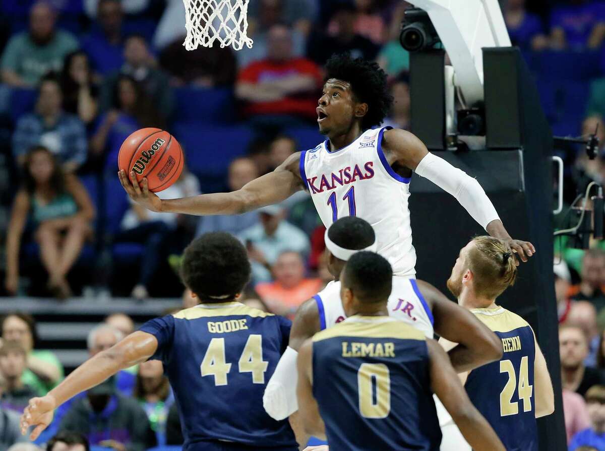 In this March 17, 2017, file photo, Kansas's Josh Jackson (11) goes up for a shot over UC Davis's Garrison Goode (44), Brynton Lemar (0) and Mikey Henn (24) in the first half of a first-round game in the men's NCAA college basketball tournament in Tulsa, Okla. The top forwards in ThursdayÂ?’s NBA draft needed only a season in college to secure their position in the lottery. KansasÂ?’ Josh Jackson and DukeÂ?’s Jayson Tatum are one-and-done small forwards with size and athleticism, while Florida StateÂ?’s Jonathan Isaac and ArizonaÂ?’s Lauri Markkanen headline the crop of power forwards or stretch-4s with the potential to play inside or out.