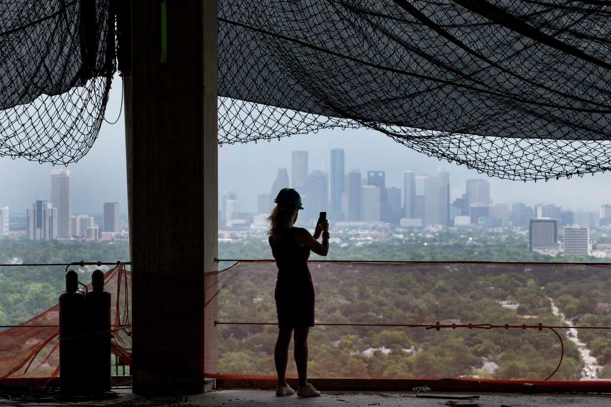 DeeAnn Thigpen takes a photo from the 26th floor, with a view of downtown, at Arabella, a 33-story residential tower under construction just inside the West Loop off San Felipe. Many potential residents also like a view of the Uptown area. ﻿