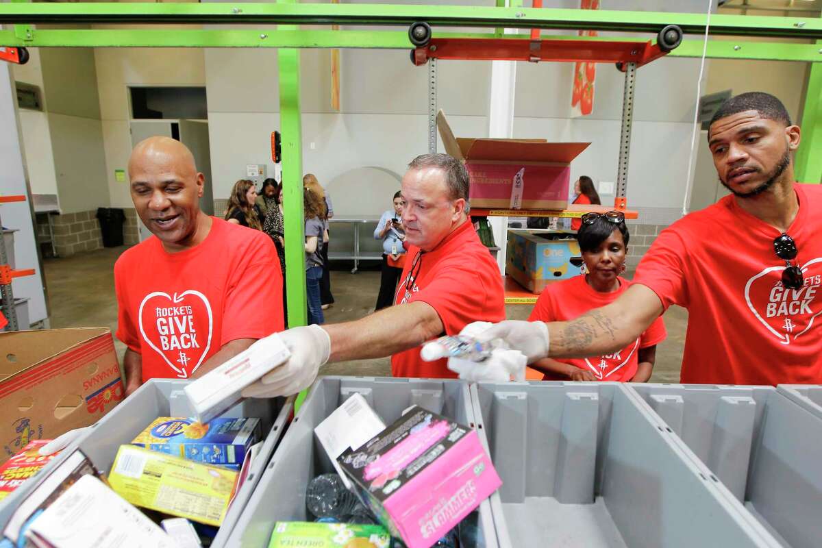 Houston Rockets Mario Elie (l-r), Vice President Tad Brown, Sarah Joseph and Mo Taylor work at Houston Food Bank Tuesday, June 20, 2017, in Houston. ( Steve Gonzales / Houston Chronicle )