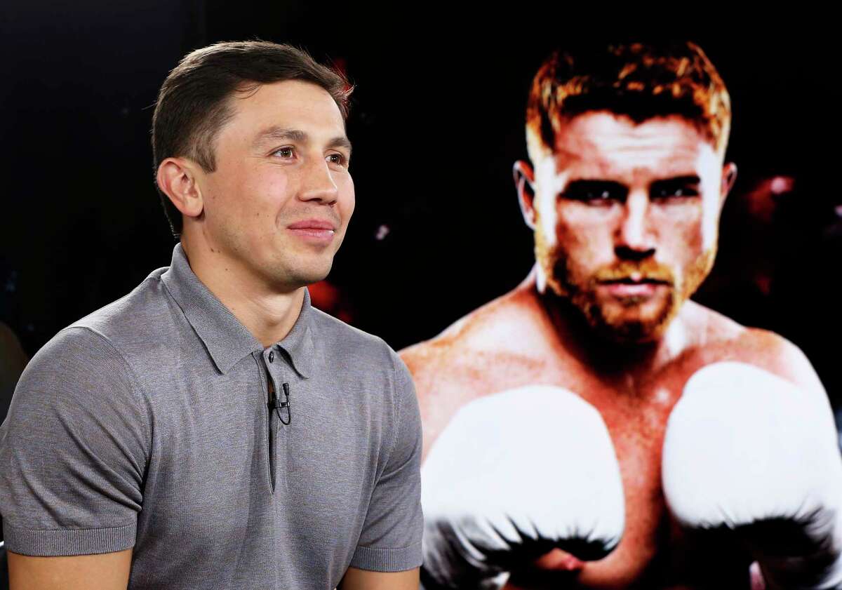 IBF and WBC world middleweight boxing champion Gennady Golovkin, left, poses beside a giant photograph of his upcoming opponent, six-time title holder Saul "Canelo" Alvarez of Mexico, during an interview ahead of their Sept. 16th Las Vegas superfight, Tuesday, June 20, 2017, at The Associated Press in New York. (AP Photo/Kathy Willens)