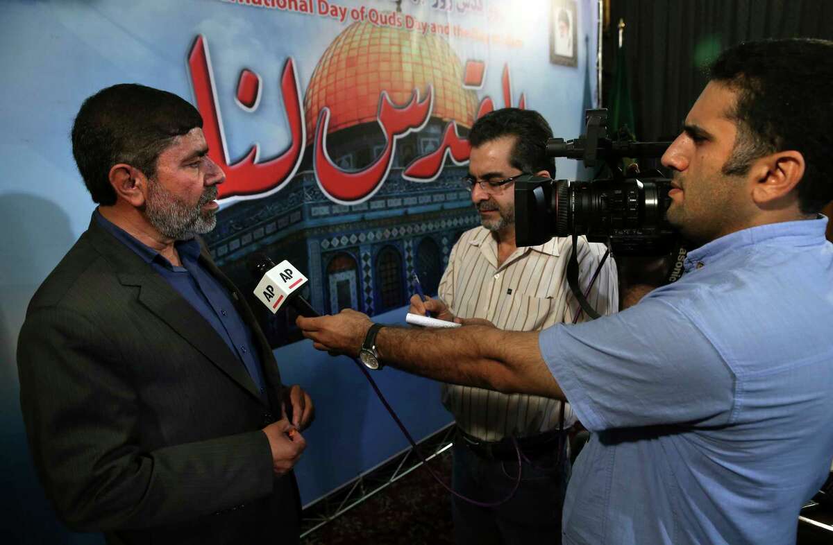 The spokesman of Iran's Revolutionary Guard, Gen. Ramazan Sharif, left, speaks with The Associated Press reporters at the conclusion of his press conference in Tehran, Iran, Tuesday, June 20, 2017. Sharif, said all six ballistic missiles it launched on Syria hit their targets, according to "local sources and drone films." Iran fired ballistic missiles at IS targets in eastern Syria, in the province of Deir el-Zour, later on Sunday. (AP Photo/Vahid Salemi)