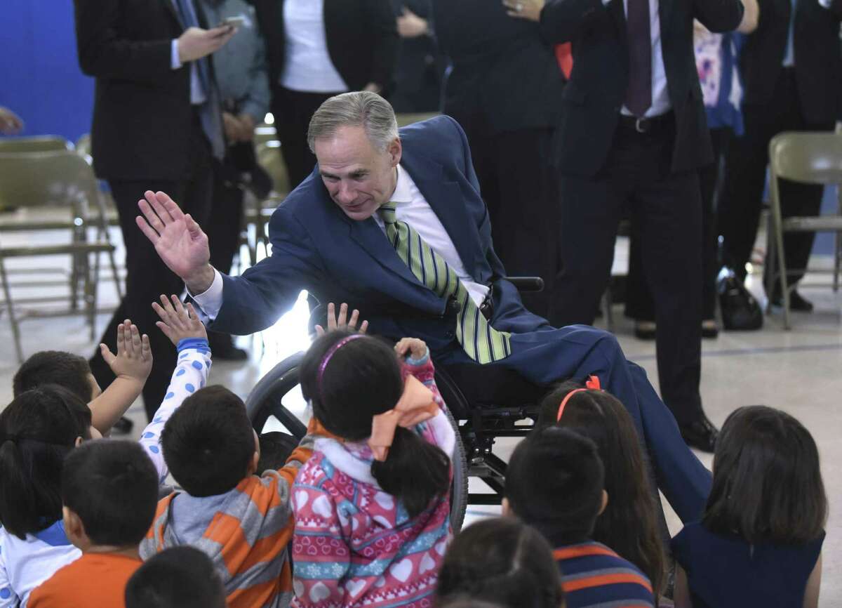 Texas Gov. Greg Abbott gives high-fives to children at Barrera Veterans Elementary School in the Somerset Independent School District earlier this year.