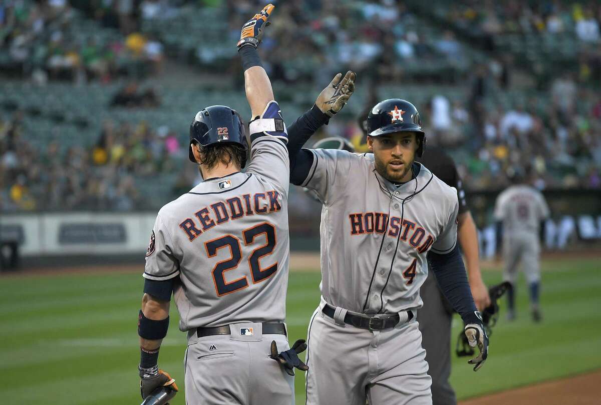 OAKLAND, CA - JUNE 20: George Springer #4 of the Houston Astros is congratulated by Josh Reddick #22 after Springer hit a lead off home run against the Oakland Athletics in the top of the first inning at Oakland Alameda Coliseum on June 20, 2017 in Oakland, California.