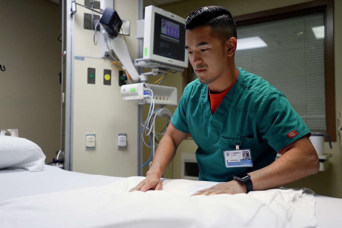 Thomas Pham, a registered nurse at Christus St. Elizabeth Hospital, prepares a bed for a patient during his shift in the intensive care unit on Tuesday. Photo taken Tuesday 6/13/17 Ryan Pelham/The Enterprise
